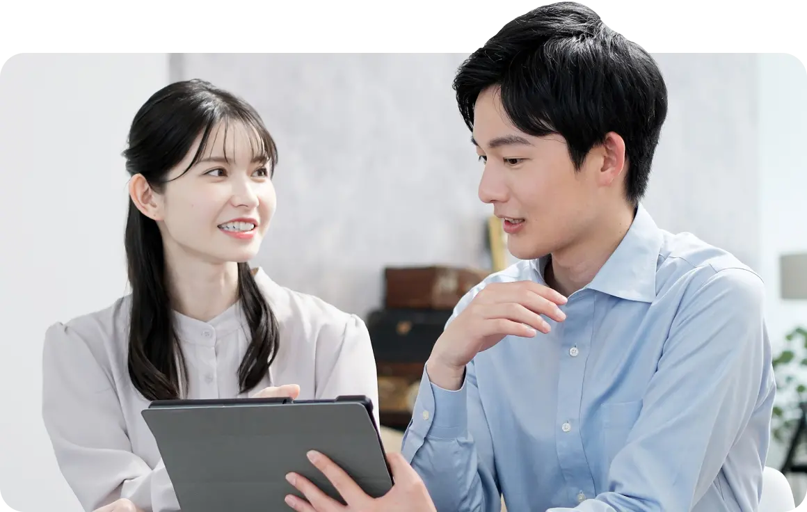 タブレットを見ながら打ち合わせをする男女